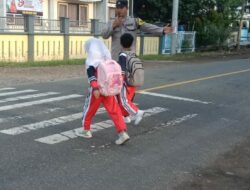 Wujud Polisi Humanis, Brigadir Wawan Satria Atur Lalu Lintas Saat Anak Sekolah di Desa Goa